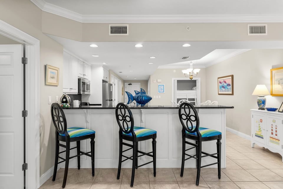 Modern kitchen bar area with three stools and open layout