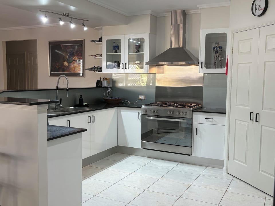 Kitchen with stone benchtops, 900mm wide stainless steel oven and gas cooktop.