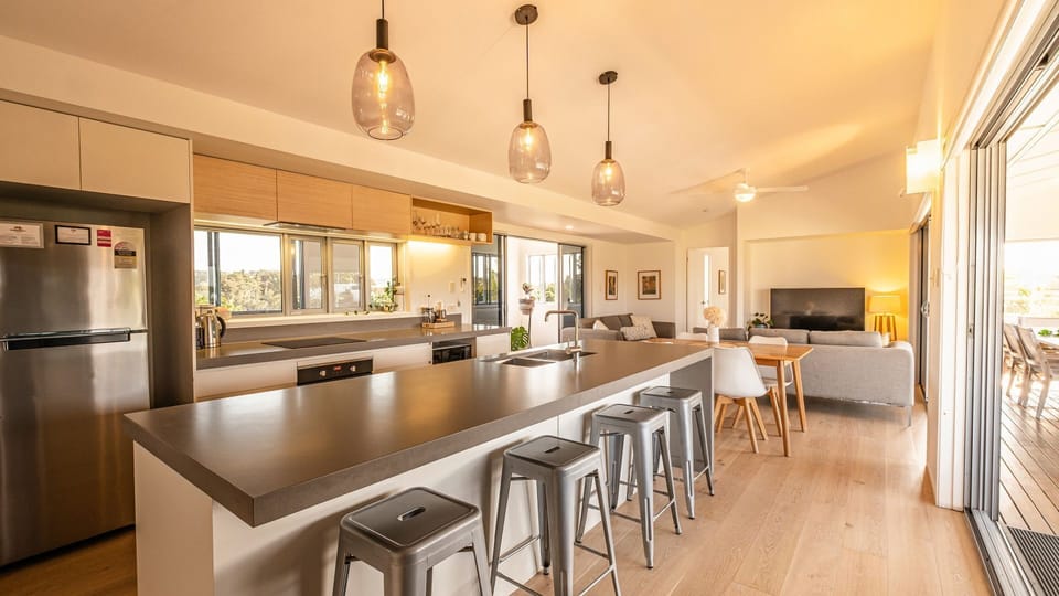 Entertainer’s kitchen with sleek island, open to lounge and views