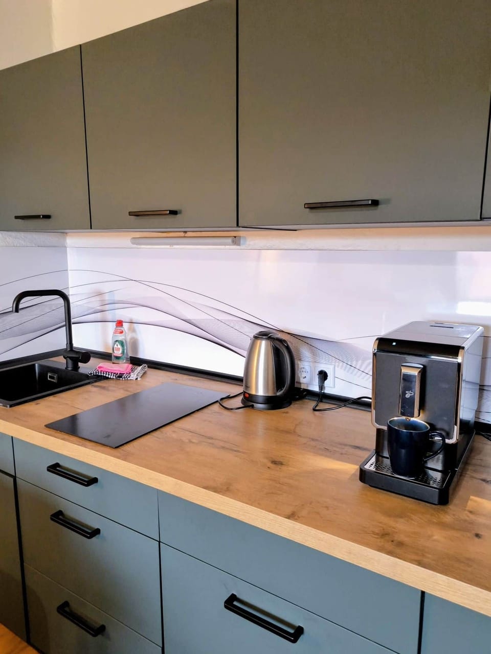 Dein Barista-Moment im Harz: Starte den Morgen mit einem frisch gemahlenen Kaffee aus unserem hochwertigen Vollautomaten. Die moderne Küche in Salbeigrün bietet dir alles, was du für ein entspanntes Frühstück brauchst.