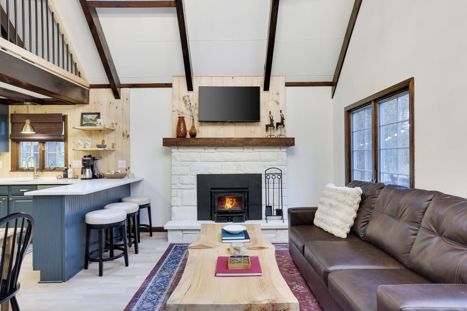 Bright living space with a TV and wood burning fireplace 