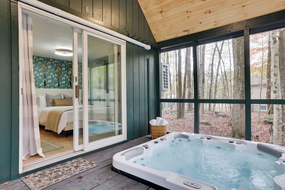 This relaxing bedroom opens to a screened in porch with a hot tub