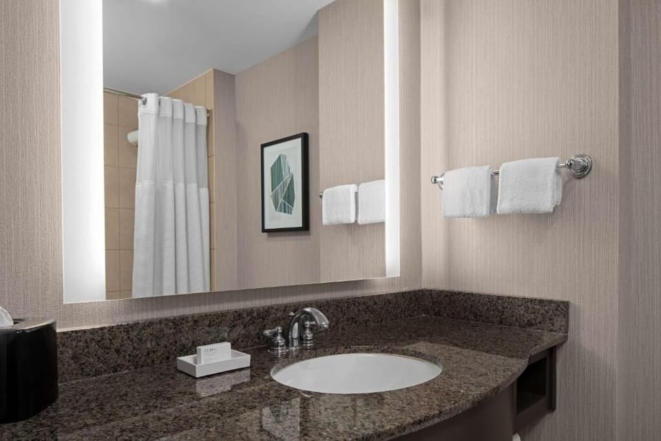 Refresh effortlessly at the sleek granite vanity with bright lighting.