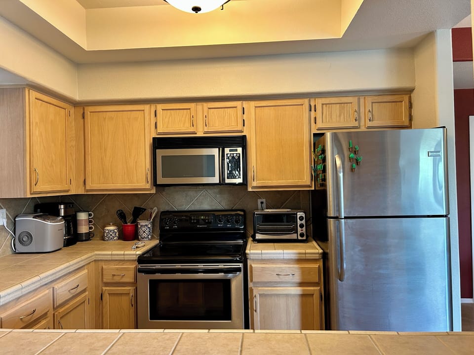 Kitchen with dishwasher, stove, microwave, toaster, drip coffee and refrigerator