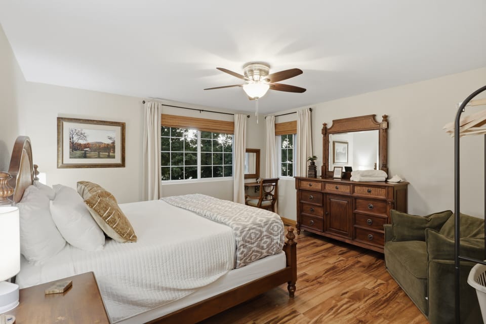 Bright, spacious bedroom with hardwood floors and peaceful window views