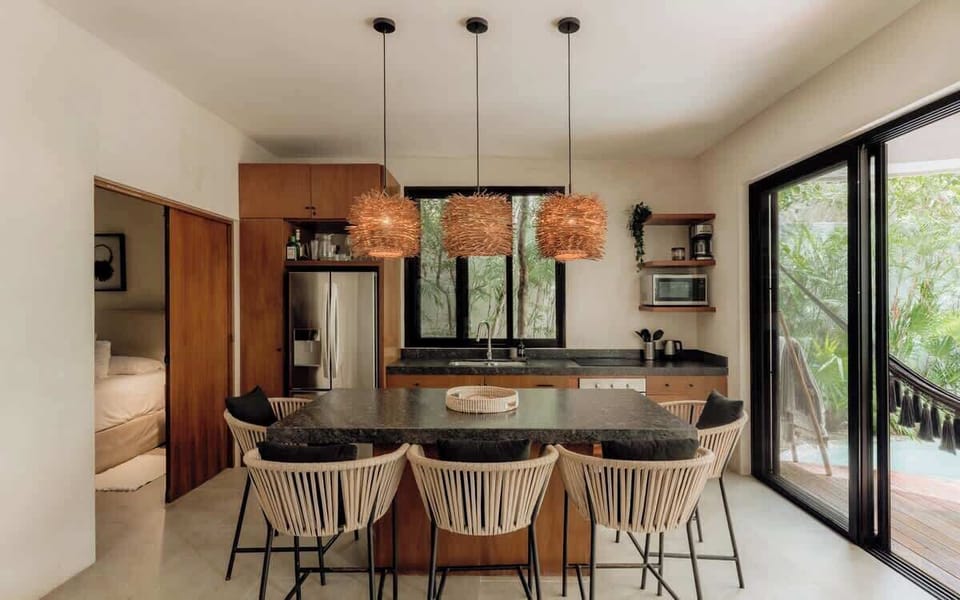 Chef's kitchen with copper rattan pendant lights, dark stone island, and premium appliances.