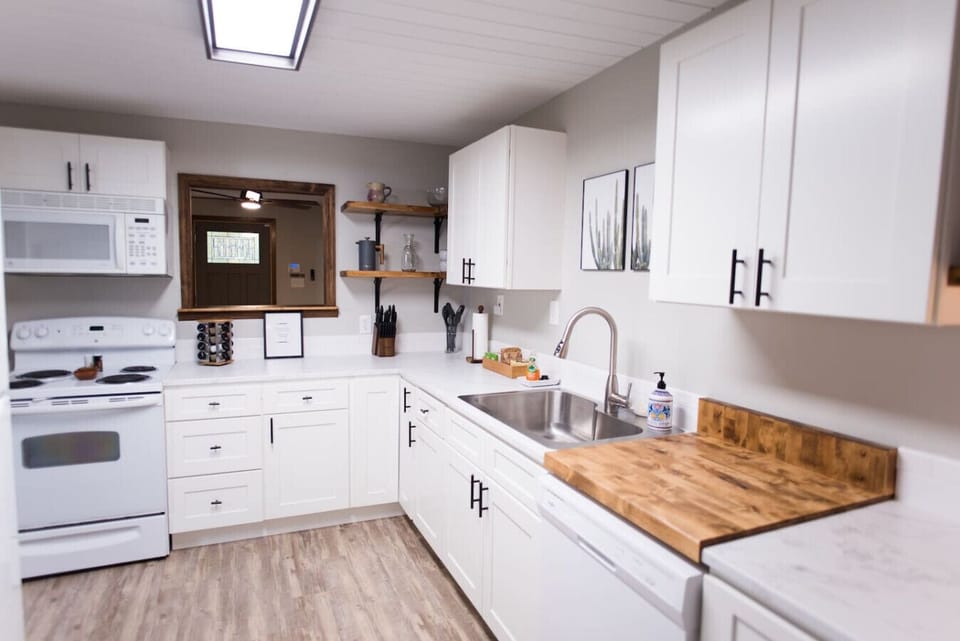 A unit kitchen with fully stocked bakeware, serve ware, and multiple appliances