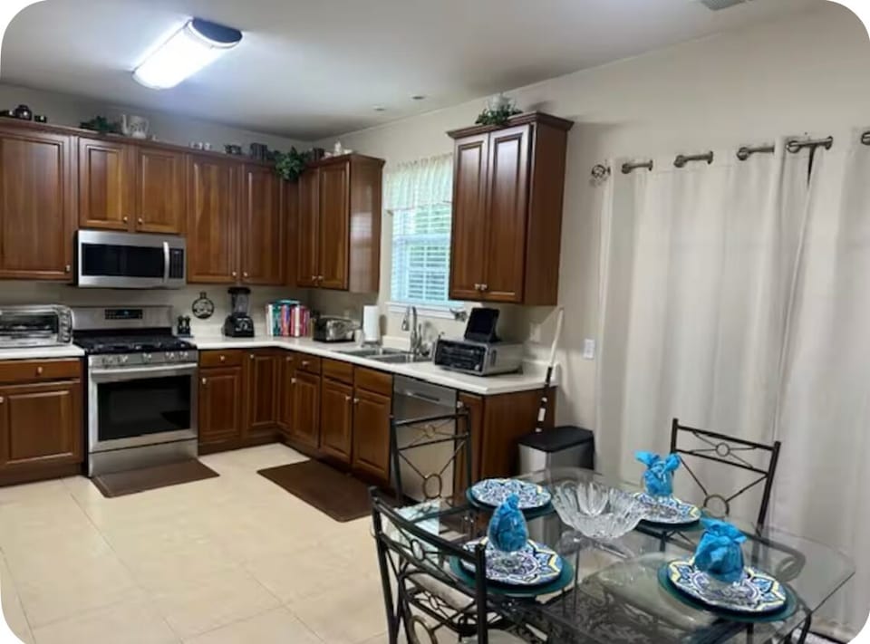 Eat-in kitchen fully stocked with utensils, bakeware, and appliances.