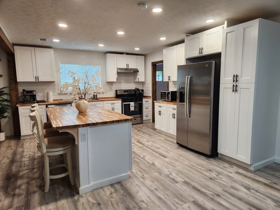Bright kitchen with island, pantry, and stainless fridge
