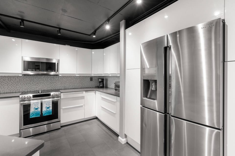 Updated, Fully Equipped Kitchen with Sleek White Cabinets and Stainless-Steel Appliances