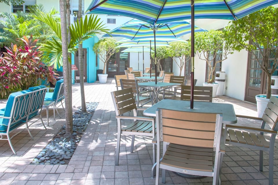 Sip morning coffee outside beneath cool striped umbrellas.