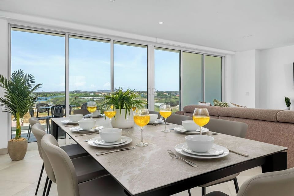 Enjoy meals with sweeping natural views through floor-to-ceiling windows, blending modern elegance with a welcoming dining experience perfect for gathering together.