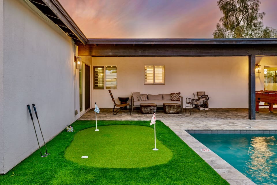 Private poolside putting green with cozy covered patio lounge
