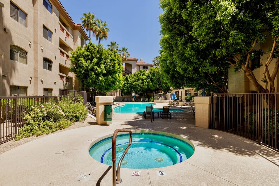 Resort-style pool and spa oasis with shady seating and lush landscaping