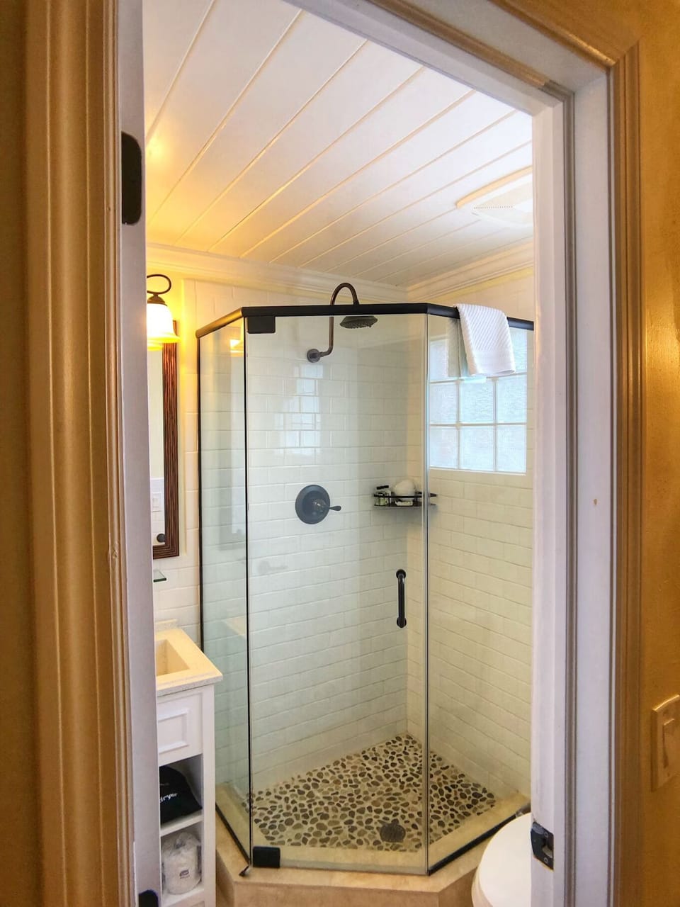 Refresh under a spacious glass shower with pebble floor.