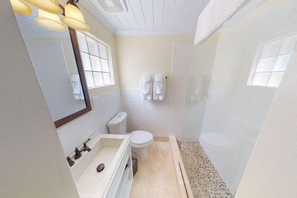 Refresh in a bright bath with walk-in shower and fluffy towels.