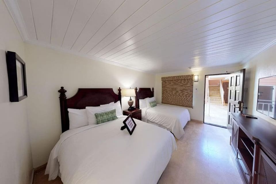 Unwind in bright double-queen comfort with breezy patio access.
