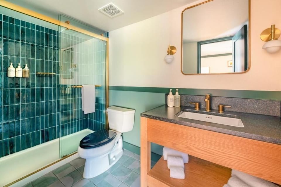 Refresh in a spa‑bright bath with glass shower and brass accents.