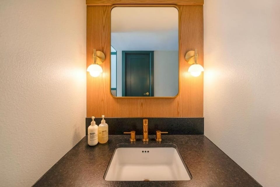 Start the day at a sleek vanity with glowing sconces.