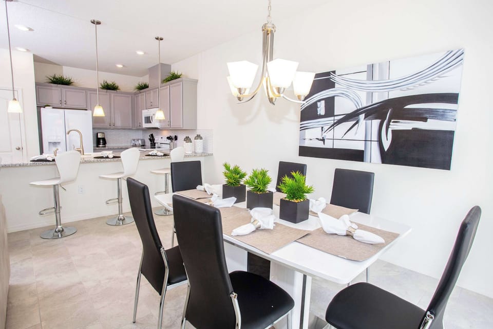 Open kitchen island with white stools and three pendant lights-the social heart for casual meals and chats.