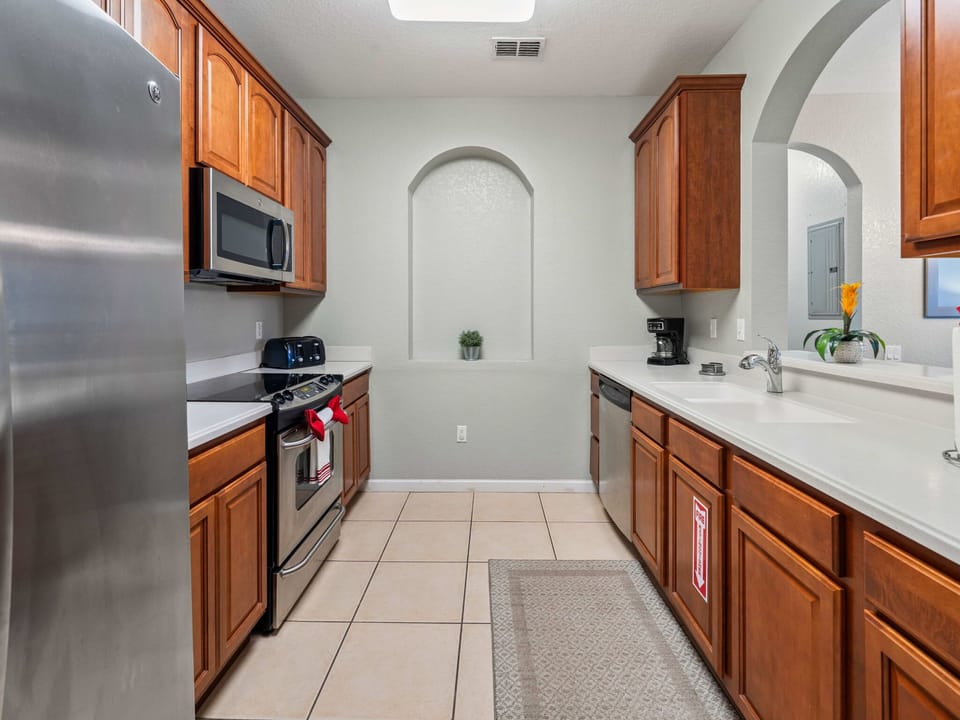 Cook with ease in the fully equipped kitchen-stainless appliances, rich wood cabinets, ample counter space, and a coffee station for morning fuel.