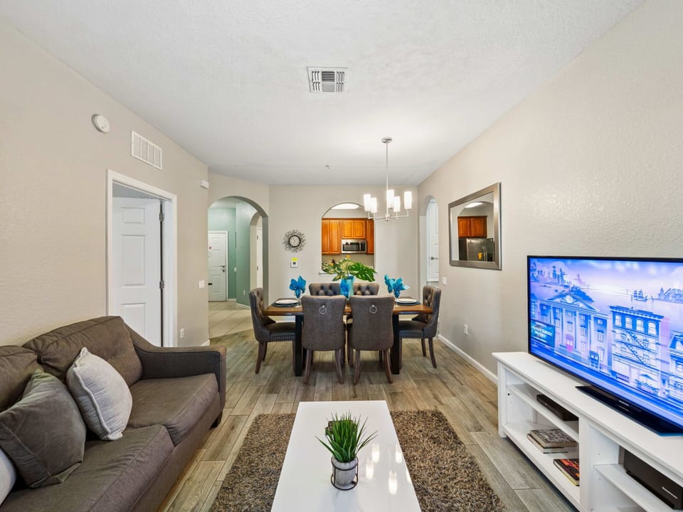 Open-concept flow from living to dining and kitchen-neutral hues, wood-look floors, and warm lighting make relaxing together easy.