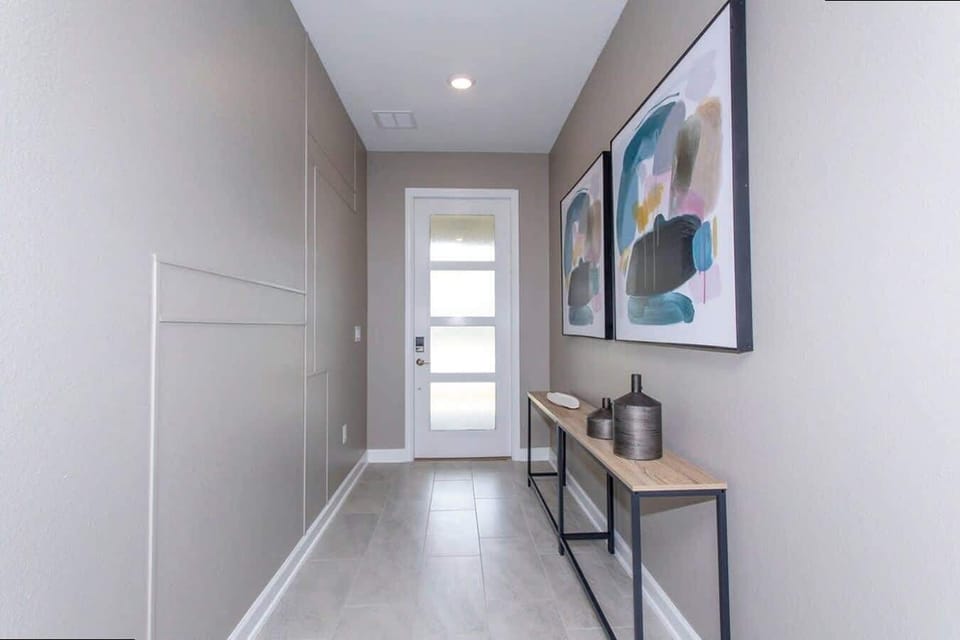 Step into style with this modern entryway, complete with sleek furnishings, contemporary art, and warm neutral tones to welcome you home.