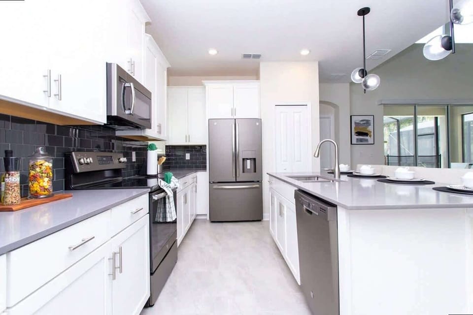 This bright, modern kitchen with stainless steel appliances and spacious island is perfect for social cooking and gathering over morning coffee or dinner.