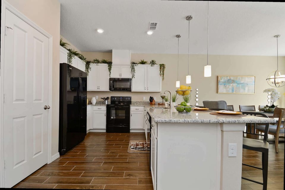 Gather around the granite-topped breakfast bar under soft pendant lighting—our stylish kitchen’s perfect spot for morning coffee.