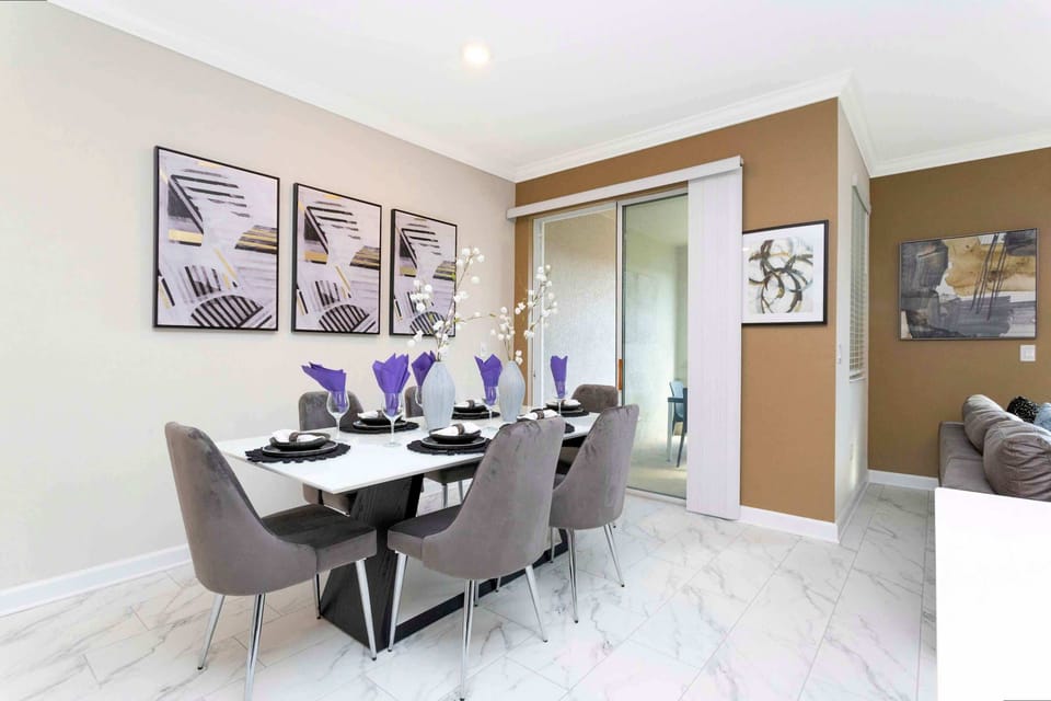 Host memorable dinners in this chic dining area for six, featuring marble-look tile floors, plush velvet chairs, and eye-catching wall art-plus a sliding door to the sunny outdoor patio!