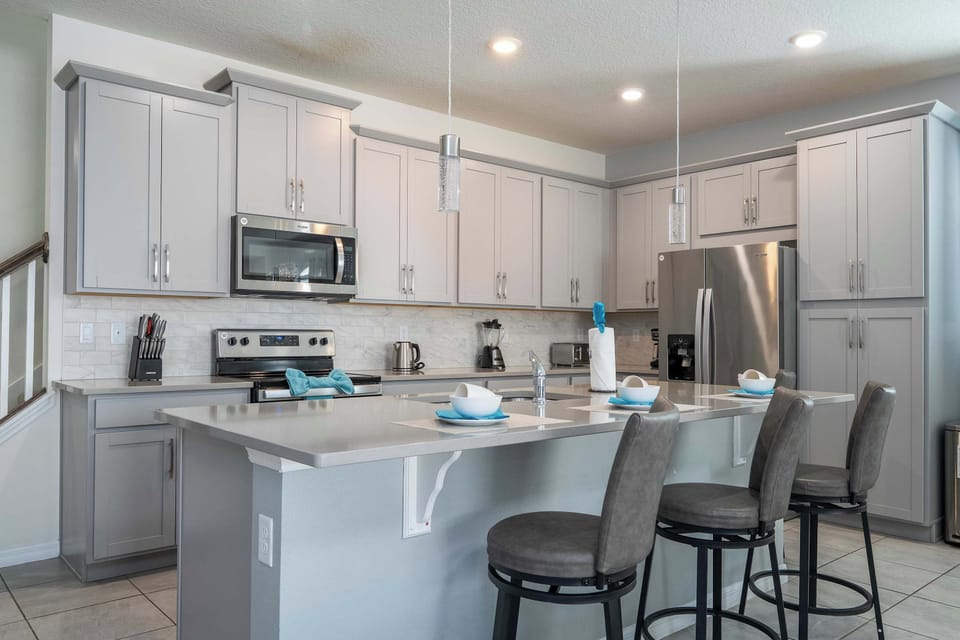 Chef-ready kitchen: long breakfast bar for four, shaker cabinets, and full stainless suite-cook together in style.