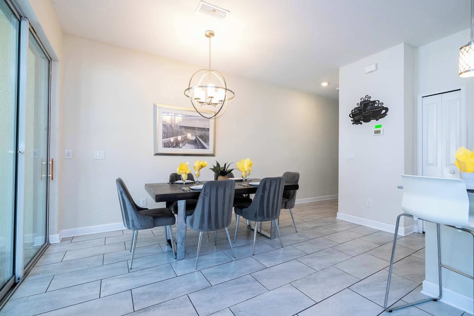 Share delicious meals around this modern dining table, set for six under a striking chandelier-a perfect spot for family feasts and cheerful conversations.