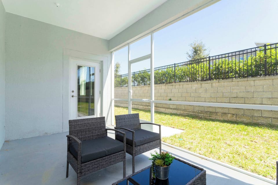 Unwind on the screened patio with comfy rattan seating and a small grassy yard-your sunny, bug-free spot for morning coffee.