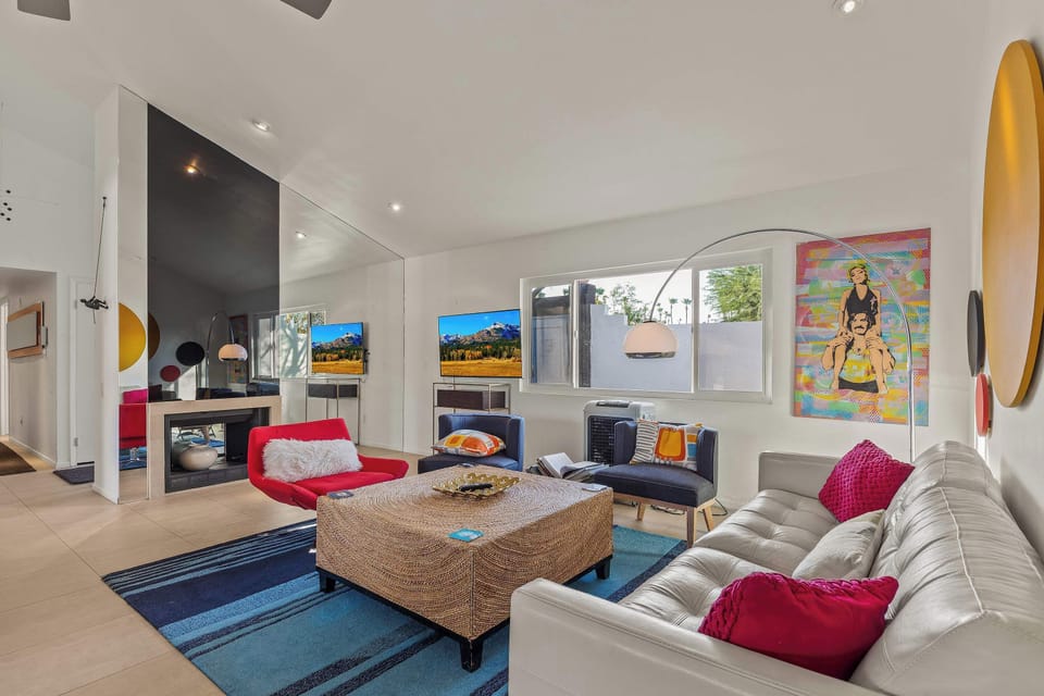 Colorful, modern living room with vibrant art & cozy seating. Perfect for relaxing after a day in the private pool.