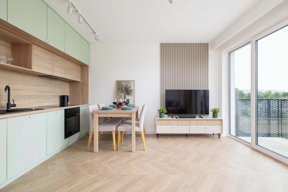 A contemporary kitchen-living area with full-height windows.
