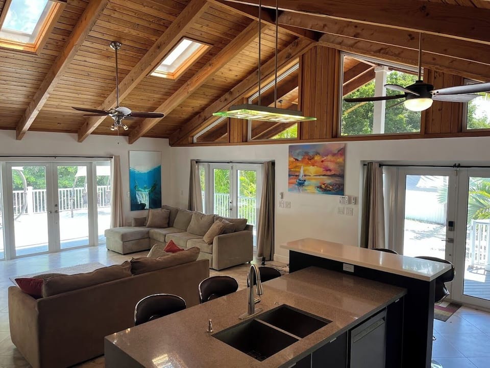 Huge open living and kitchen space with windows and skylights.