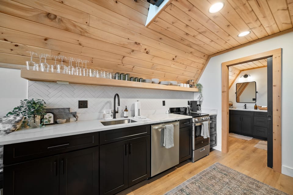 Bright and modern under a warm wood ceiling. Open shelving keeps everything within easy reach for a relaxing mountain getaway.