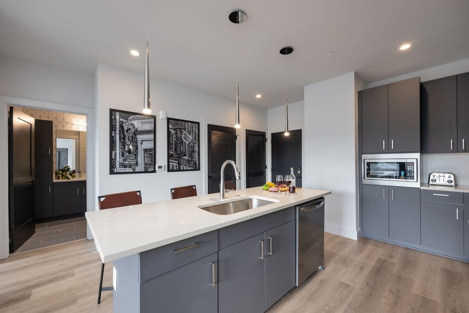 Unit 1: Fully equipped kitchen stocked with your basic cooking essentials. Includes stainless steel appliances, small kitchen island, coffee machine, and toaster.