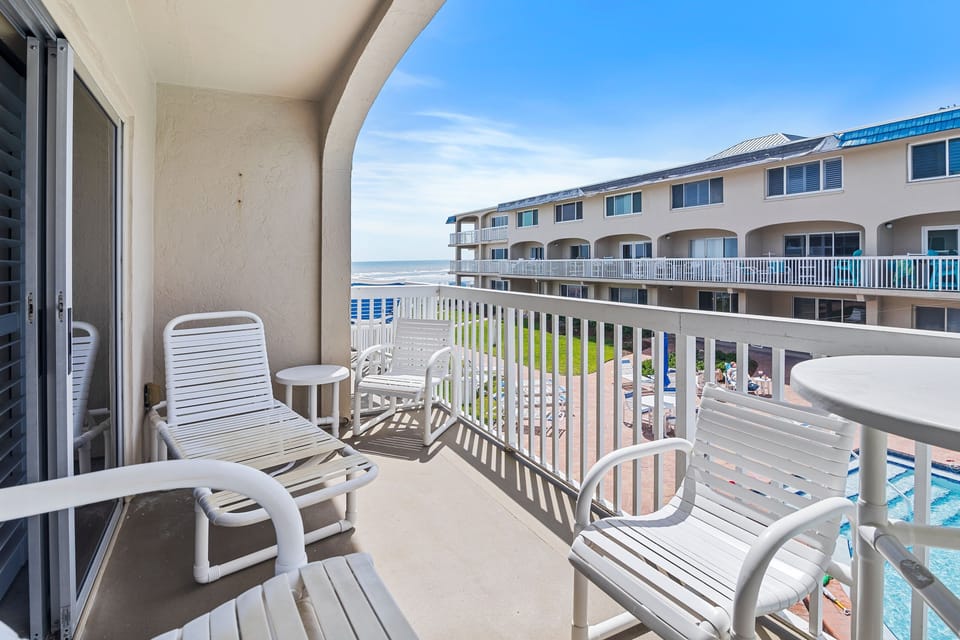 Relax on your private balcony with sweeping views of the beach and pool. Perfect for soaking up the sun, enjoying ocean breezes, and watching waves roll in during your coastal getaway.