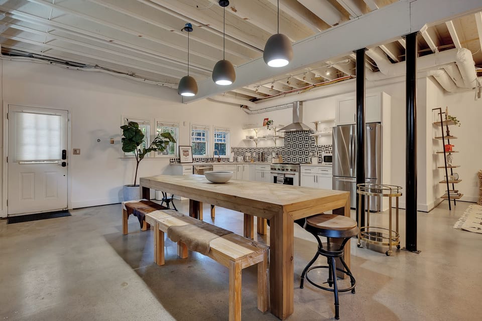 Industrial-chic aesthetic with exposed beams, pipes, and polished concrete floors