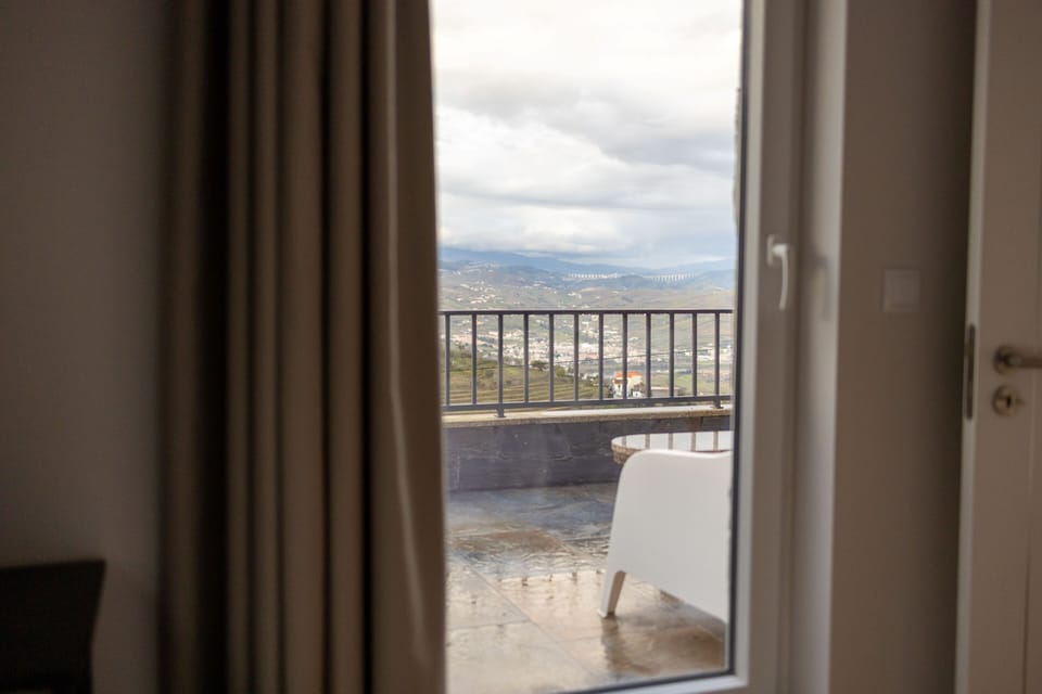 A door that leads to a spacious balcony with views of the Douro Valley. 
