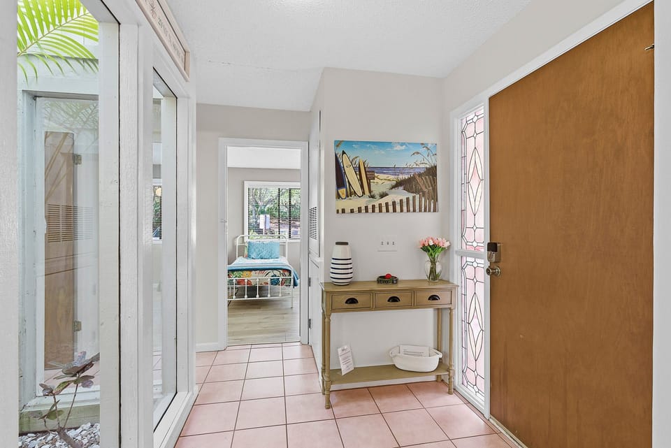 Step into a bright, beach-inspired entryway featuring coastal décor and an inviting layout that sets the tone for your stay. A warm welcome to your relaxing beach stay getaway near sun, sand, and surf.