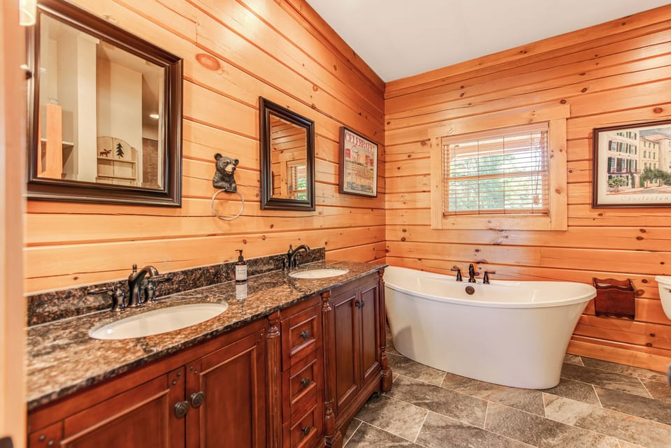 Upstairs ensuite bathroom with dual sinks, floating tub, and walk-in shower