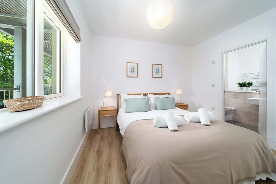 Wake up to natural light pouring through stunning windows in the bright and peaceful Tree Top bedroom.