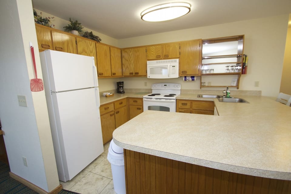 This well-equipped kitchen features warm wood cabinets and all necessary appliances, making it easy to prepare delicious meals while enjoying the beachside charm.