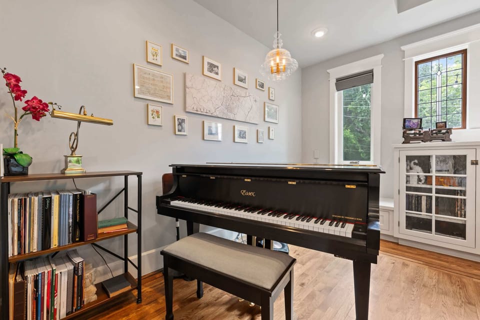 Warm & inviting living room with fireplace, smart TV and piano