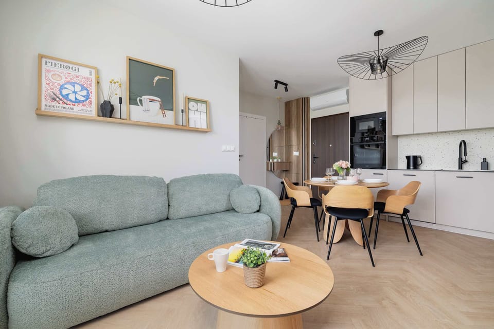 A stylish dining room with a round table and four designer chairs and a comfortable sofa with a coffee table create a bright and pleasant atmosphere.