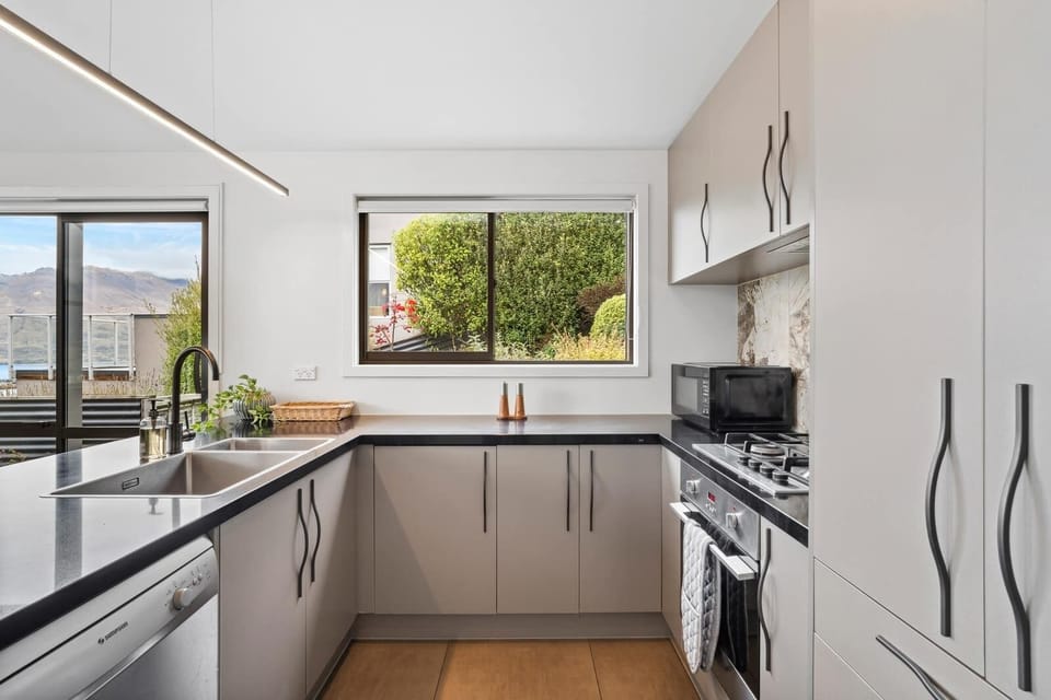 Enjoy views of both the manicured garden and glistening Lake Wakatipu as you prepare meals in this light-filled kitchen.