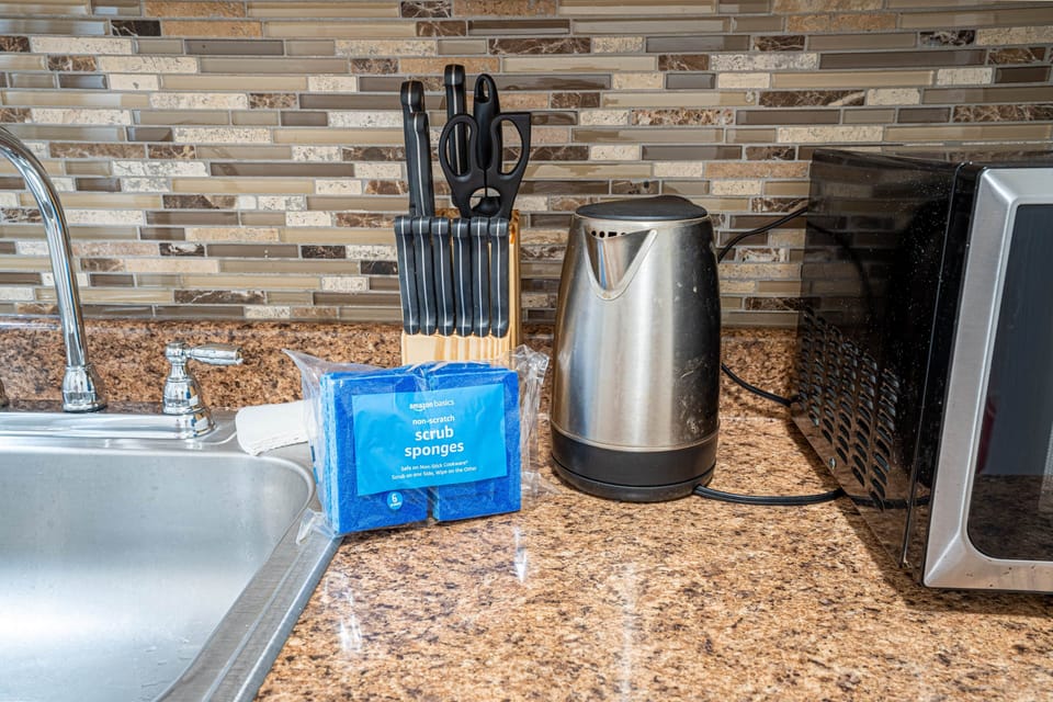 Essentials: knives, kettle, microwave, and sponges for easy cleanup