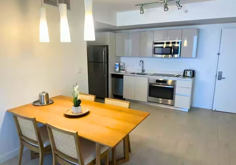 Kitchen stocked with everything you might need, including a coffee maker, refrigerator, oven, microwave, stove, utensils, and dishes